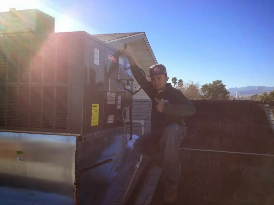 HVAC technician performing AC Tune-Up on a rooftop unit in Johns Creek